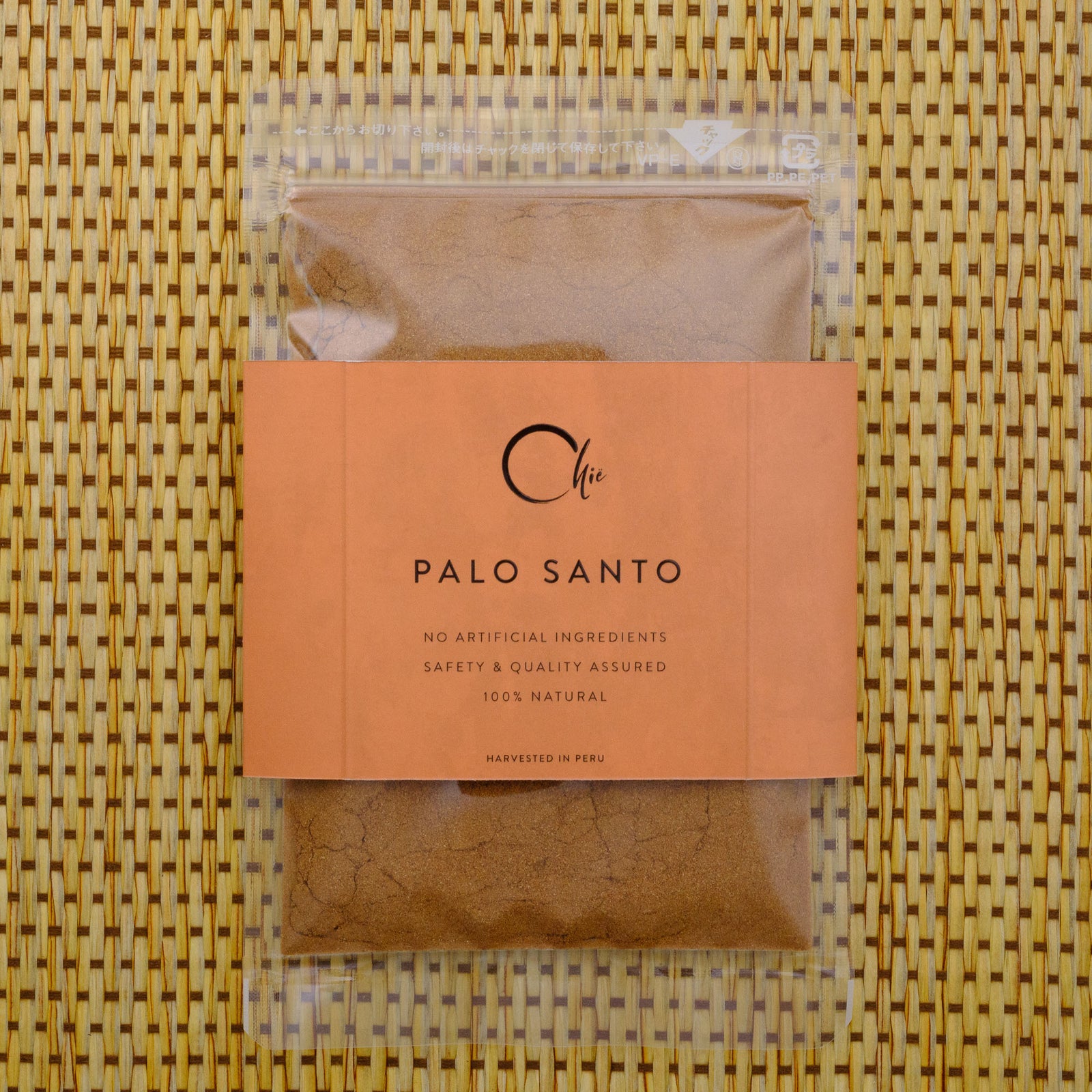 Palo Santo package with an orange label on a woven mat background