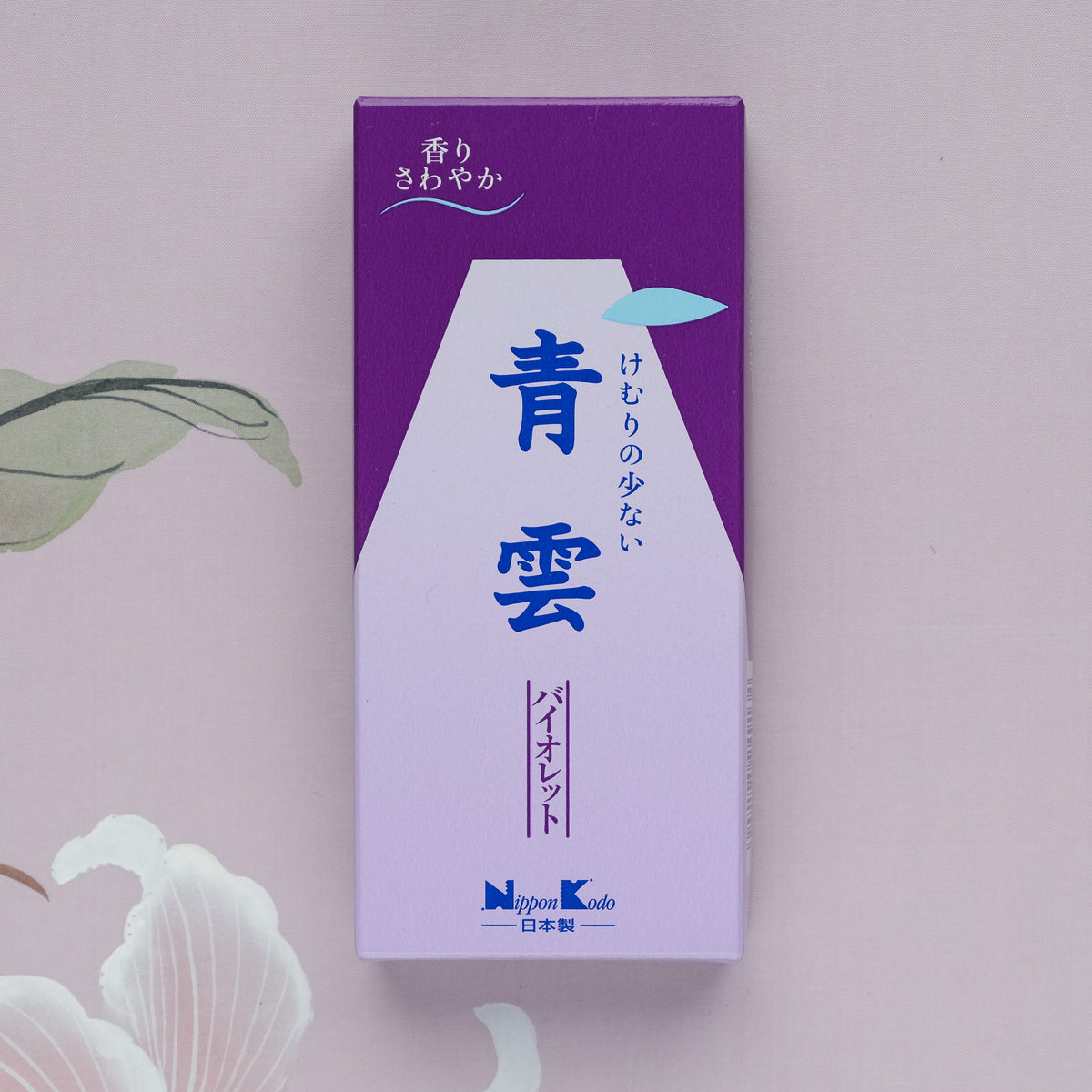 A purple and white Seiun Violet Incense box with Japanese text, set against a floral-patterned background, suggests a calming violet fragrance ideal for meditation relaxation.