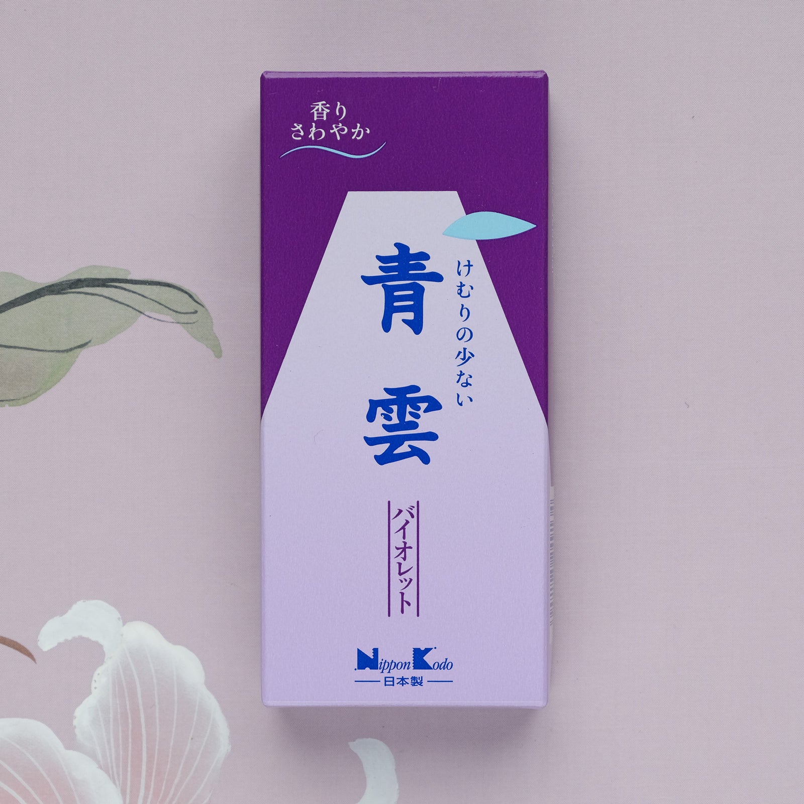 A purple and white Seiun Violet Incense box with Japanese text, set against a floral-patterned background, suggests a calming violet fragrance ideal for meditation relaxation.