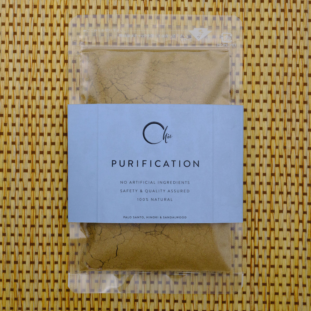 Package of &#39;Purification&#39; powder with a label on a woven mat background