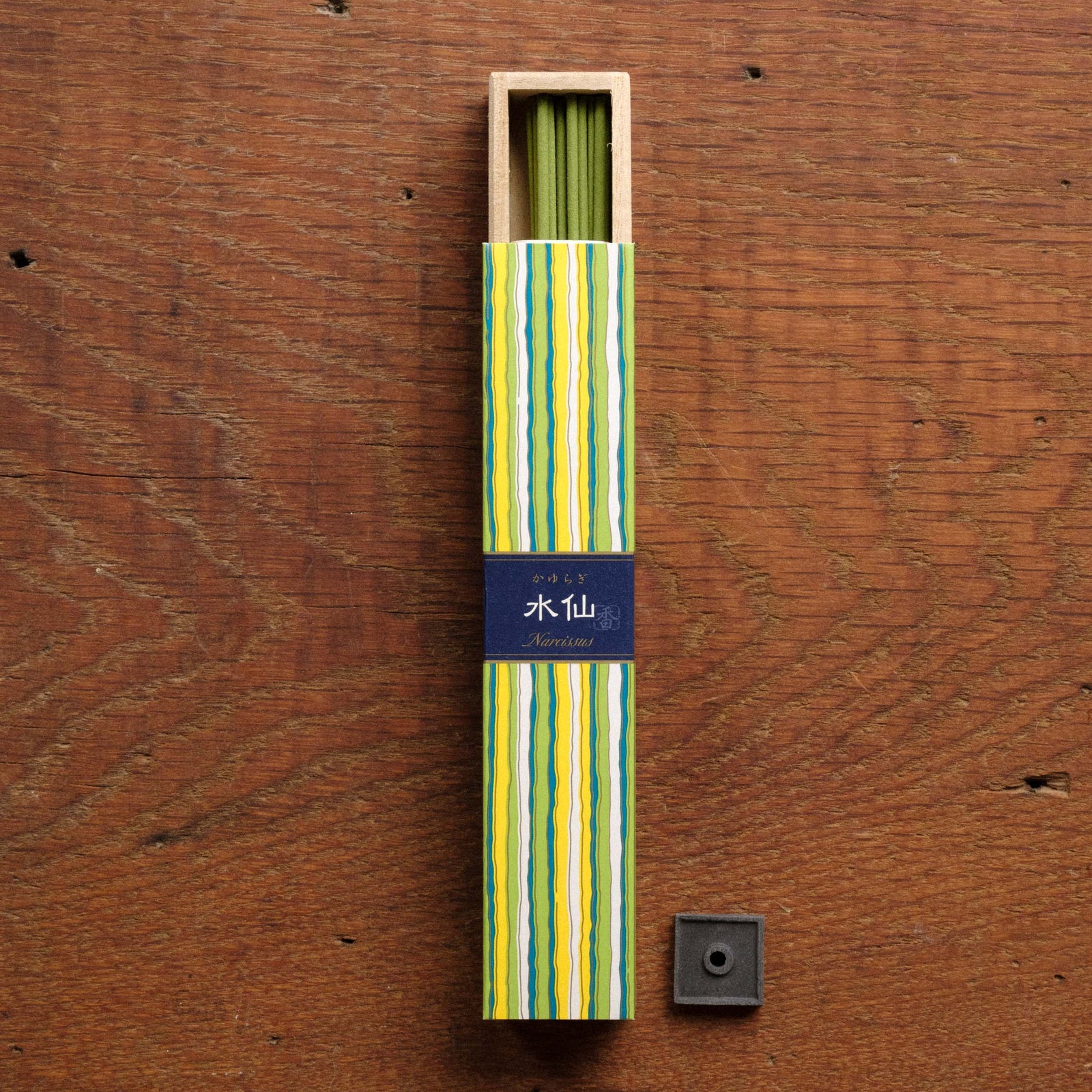 Packaged incense sticks with a blue label on a wooden surface