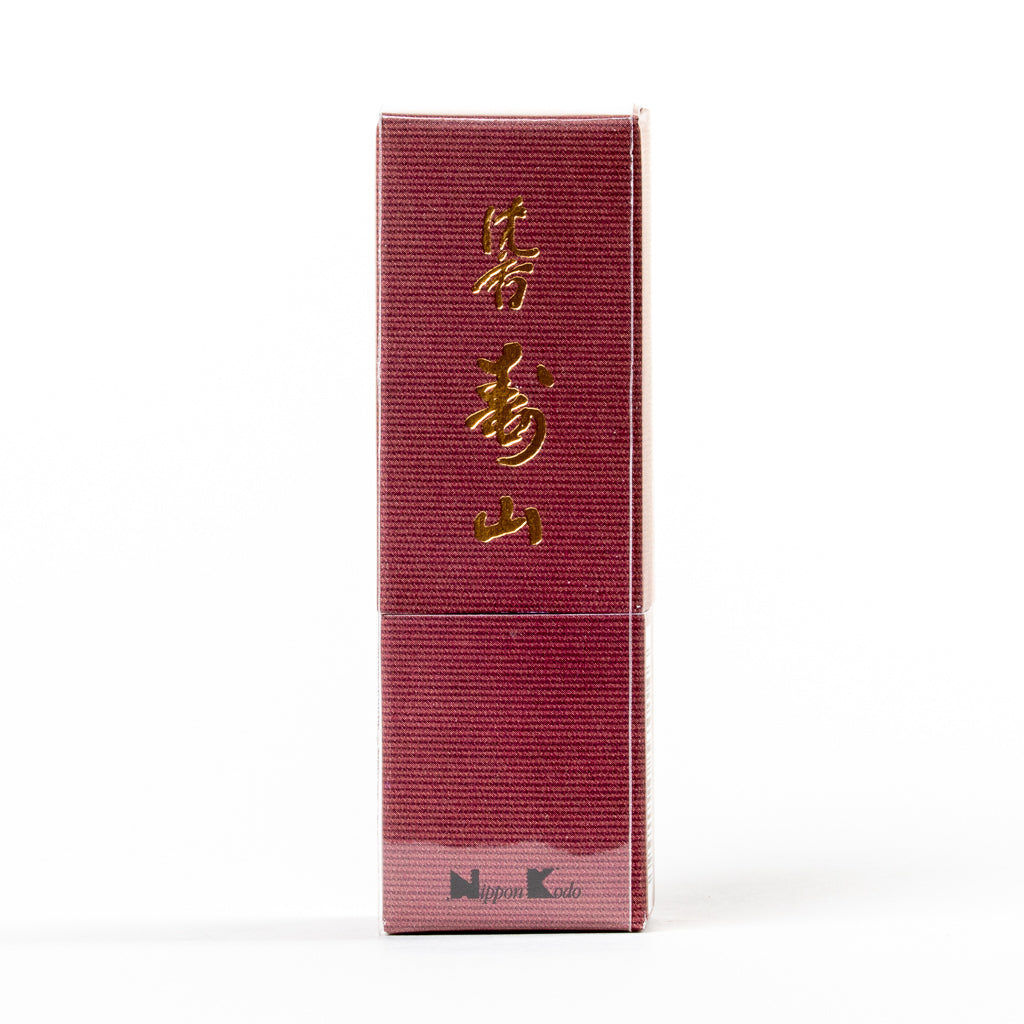 A vertical red box with gold Japanese characters highlights Jinkoh Juzan Aloeswood Japanese Incense. The bottom features the Nippon Kodo logo and an incense graphic, hinting at aloeswood. Its textured design on a white background offers an enticing look into its elegance.
