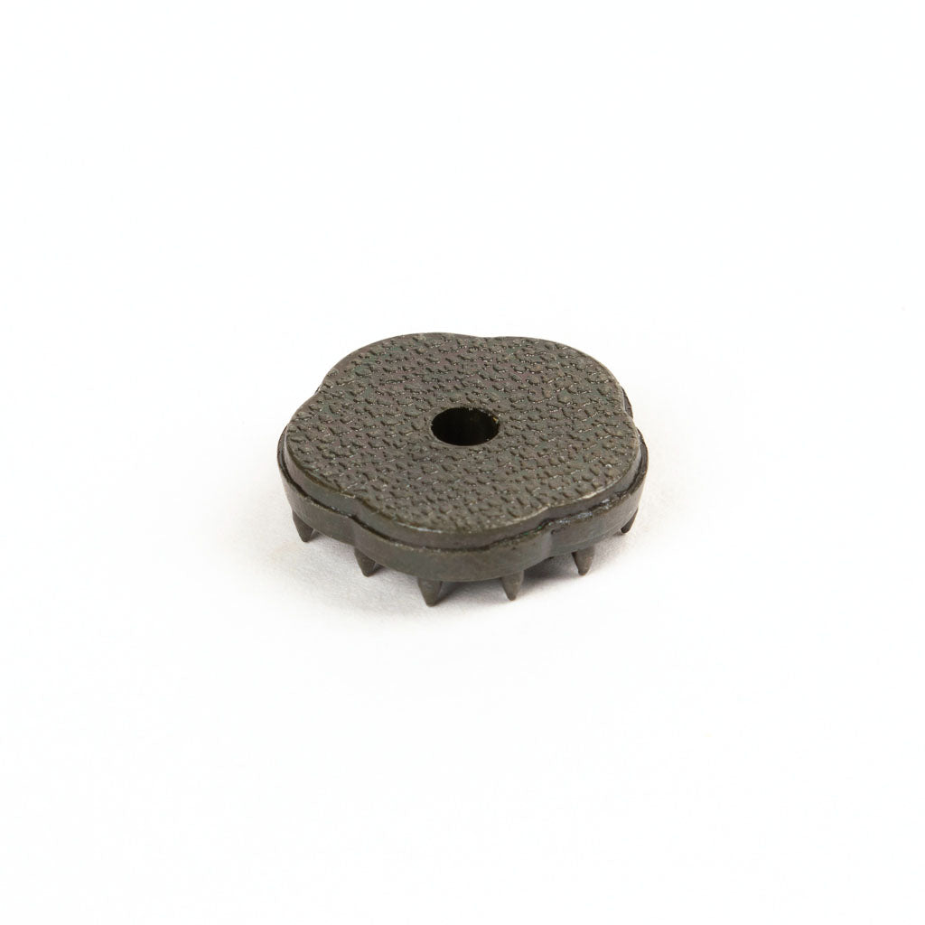 The small, round incense resembling a gear with jagged edges evokes the earthy allure of Japanese scents. Made from Jinkoh Juzan Aloeswood Japanese Incense, it rests against a plain white background.