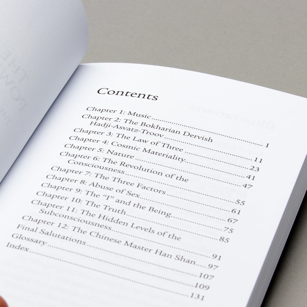 Close-up of Spiritual Power of Sound, featuring contents on music, cosmic materiality, and subconscious theory. Themes explore consciousness and energy vibrations. The book has white pages with black text against a gray backdrop.