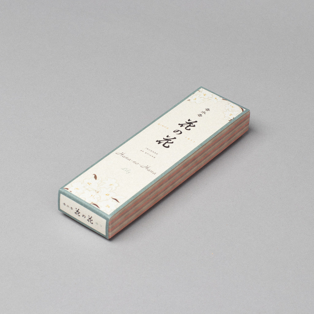 A rectangular white box labeled Hana-no-hana Floral Japanese Incense features Japanese text and a floral design on the top and sides, set against a gray background. The packaging is for sandalwood-infused floral incense sticks.