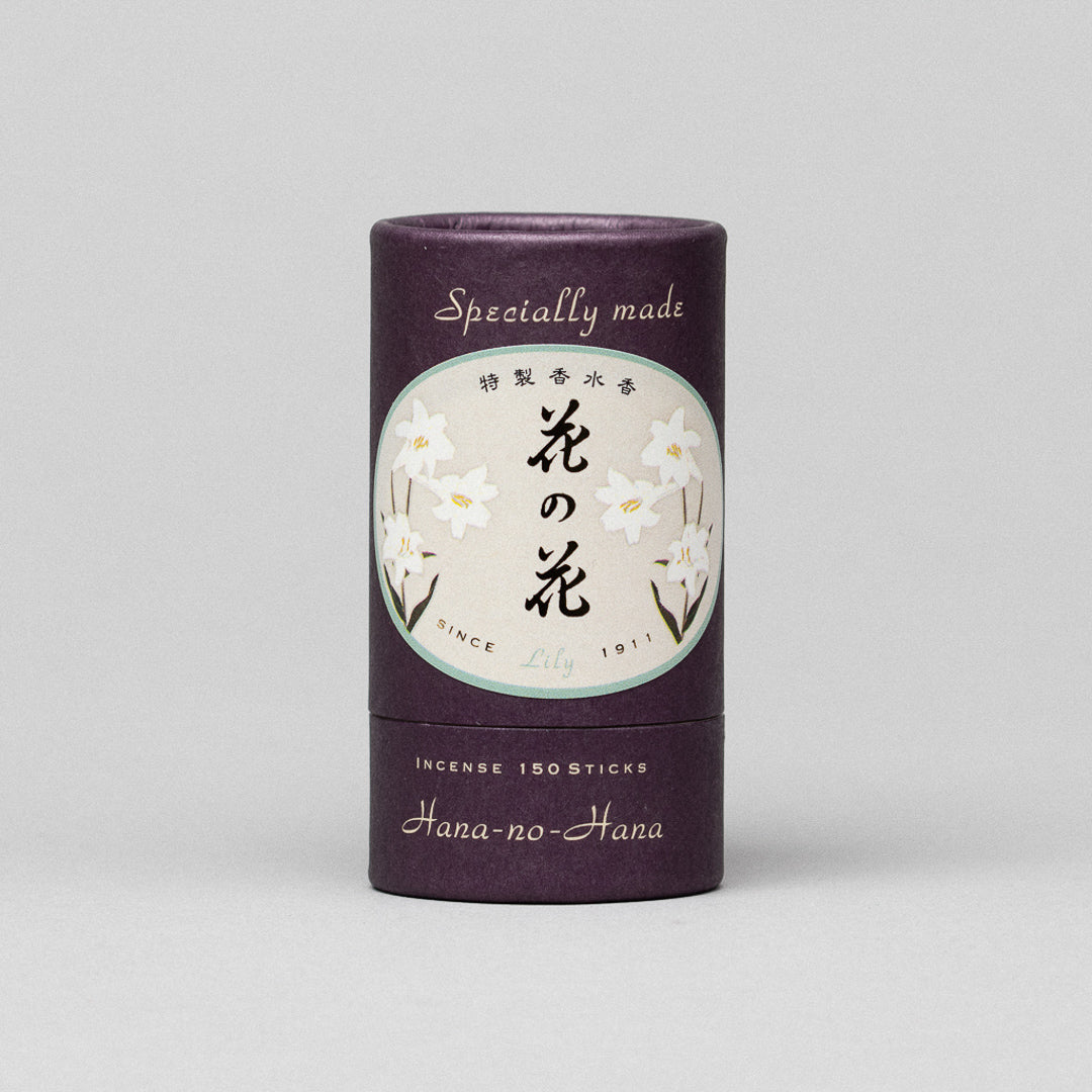 A cylindrical purple container of Hana-no-hana Premium Floral Japanese Incense with a label of white lilies and Japanese characters. It reads Specially made, Lily, Since 1911, Incense 150 sticks, in English.