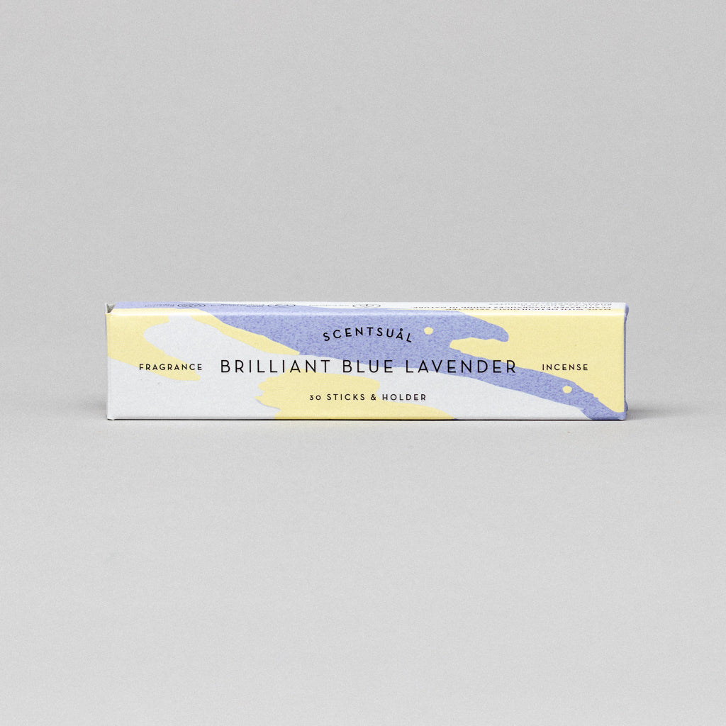 A rectangular box of Scentsual Japanese Incense, Brilliant Blue Lavender variant, features minimal packaging with a calming blue-yellow abstract design, contains 30 natural incense sticks, and includes a holder for a clean fragrance experience.