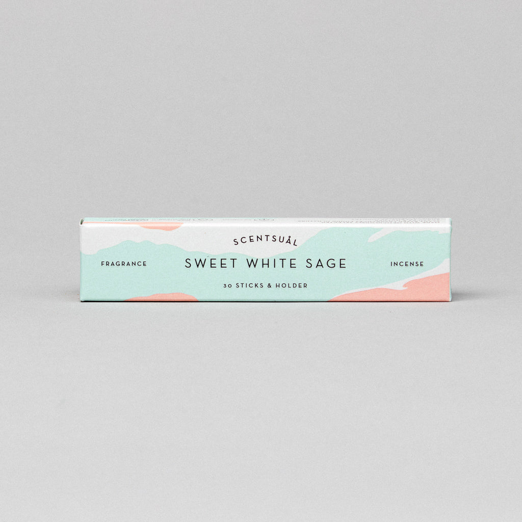 The Scentsual Japanese Incense box is designed in mint green with peach and white accents, featuring text that reads Fragrance, Sweet White Sage, and 30 sticks & holder. It offers a clean natural fragrance reflecting pure incense essence.